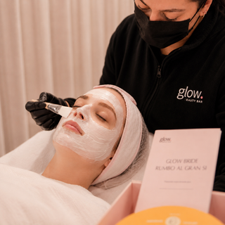Profesional de Glow Beauty Bar aplicando una mascarilla facial durante una sesión de la Membresía Novias Glow.