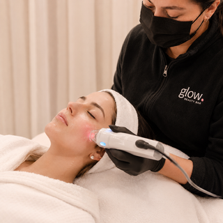 Profesional de Glow Beauty Bar realizando un tratamiento facial con aparatología a una novia.